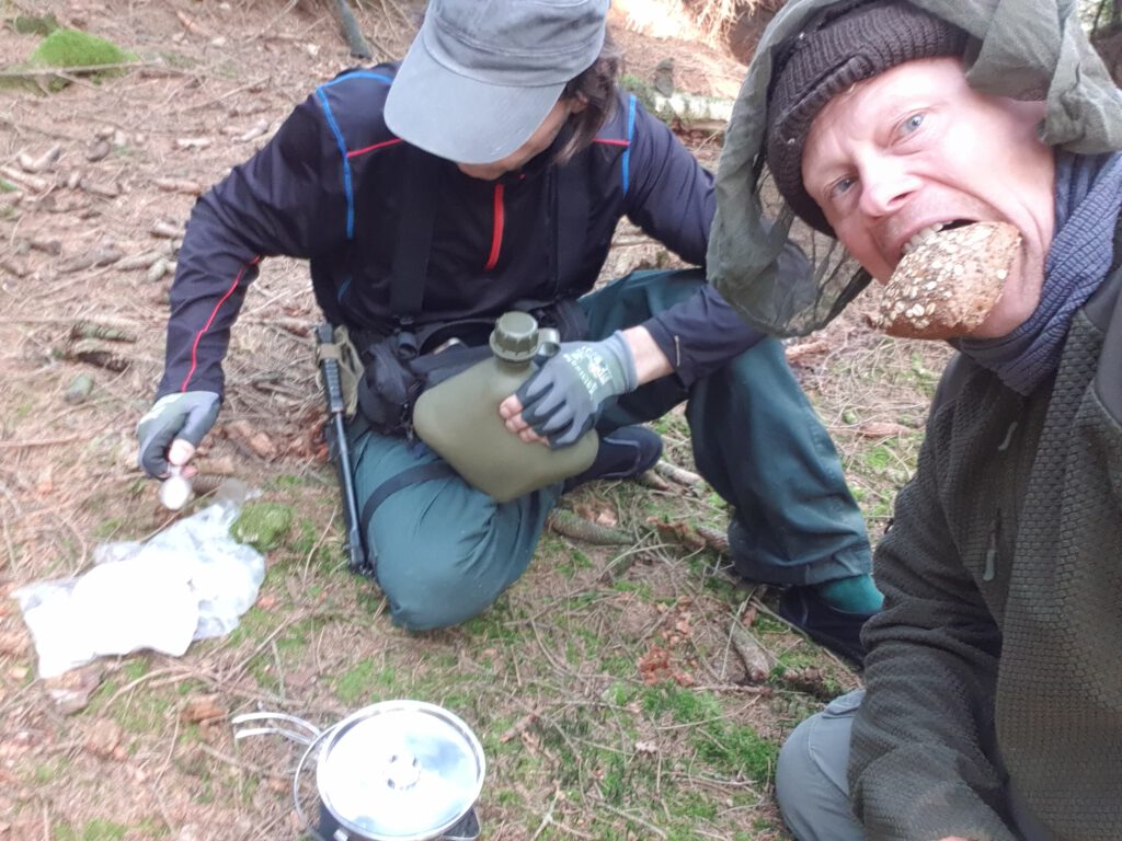 Lagerbau beim Outdoor-Training: Pause mit Nahrungsaufnahme, nachdem die Tarps aufgebaut wurden.