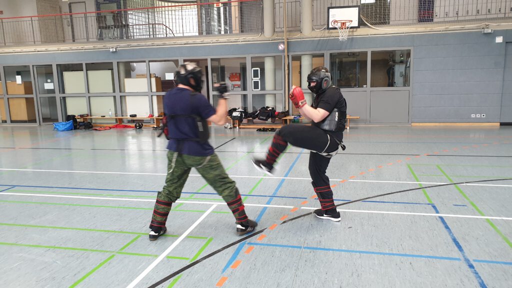 Combat Training: Schutzausrüstung bei Tritttechniken zur Verletzungsvorbeugung.