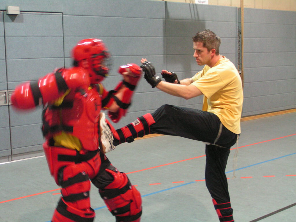 Oliver Sobach's Combat Training: Nahkampftraining. Hier ein Tritt zum Körper eines Teilnehmers gegen mich im Vollschutzanzug.